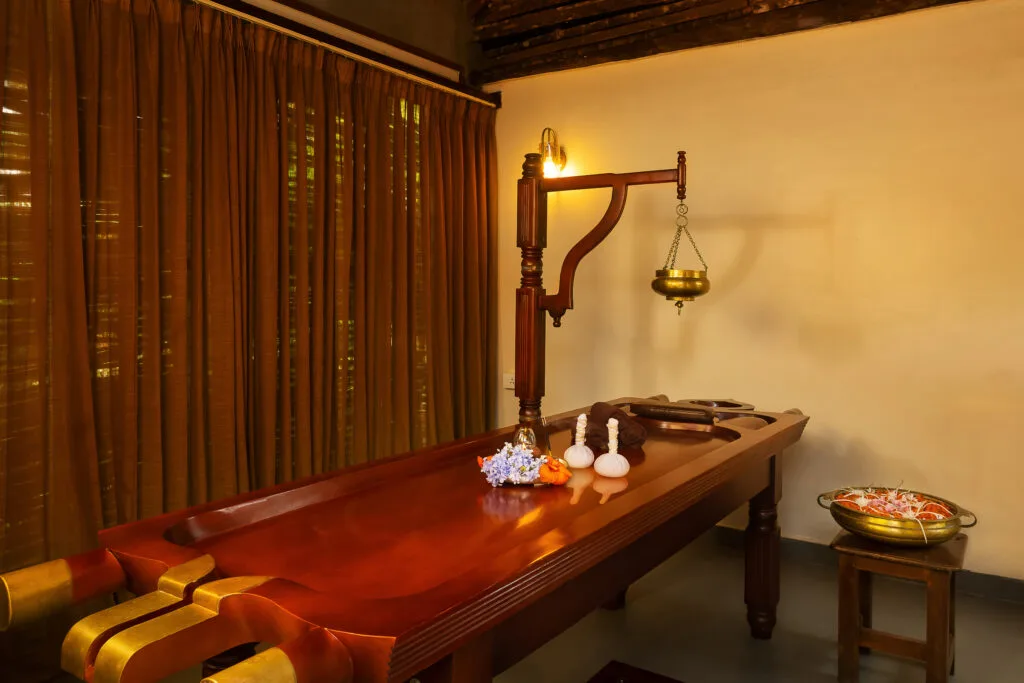 Ayurvedic massage room with traditional wooden table at Orchid Tree Wellness Retreat.